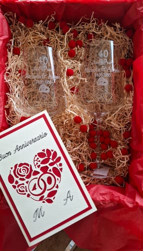 Ein Rezensent zeigt die personalisierten Weingläser zum 40. Hochzeitstag in einer roten Geschenkbox.