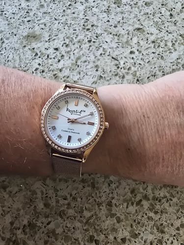 Customer's Krystal Couture rose gold watch on their wrist, showing its white face and sparkling crystal-embellished bezel.