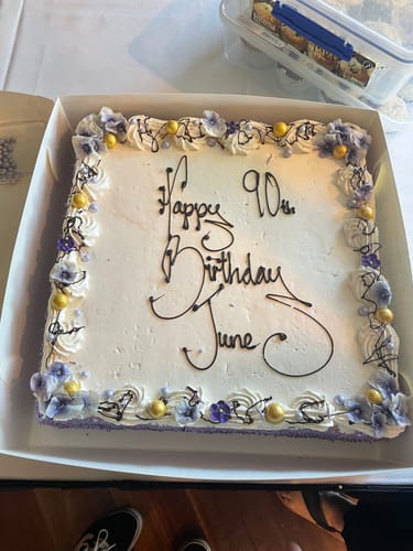 Customer's 90th birthday cake decorated with edible Light Purple Violas around the border.