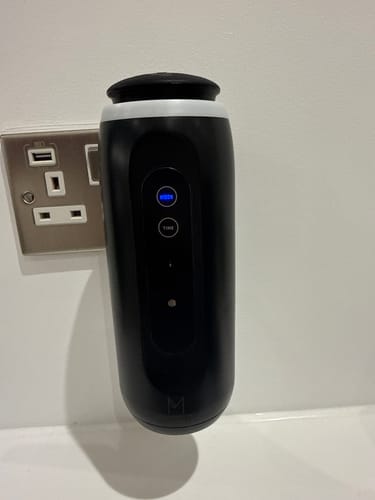 Customer's black ZenPlug smart diffuser plugged into a wall socket with the blue light on.