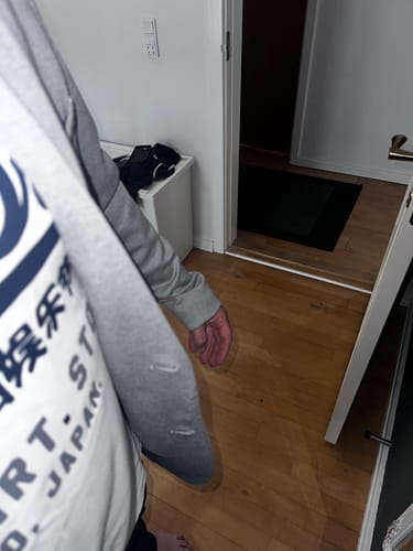 Anmelder viser den lysegrå Performance Blazer åben, set fra siden i et indendørs miljø.
