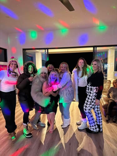 Customers celebrating at an indoor party while wearing stylish and warm ski apparel.