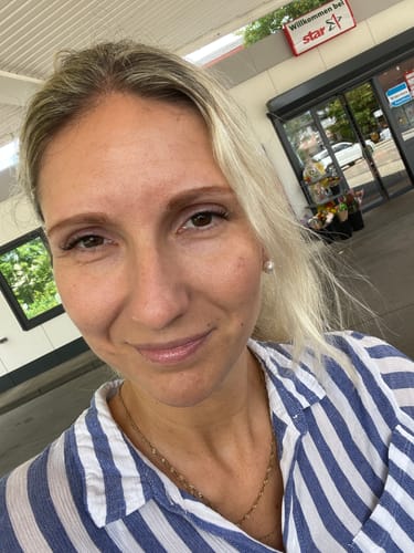 Eine Kundin zeigt die natürlich aussehenden Pretty Press Wimpern nach dem Anbringen.
