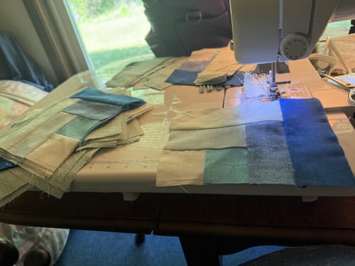 Customer's Universal Extension Table in use, providing a large surface for sewing quilt blocks on a machine.