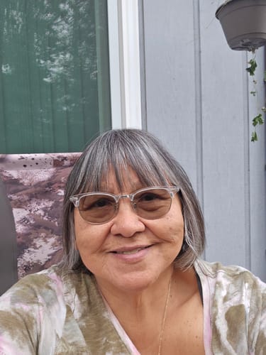 A close-up of a happy reviewer with short graying hair and glasses, smiling at the camera.
