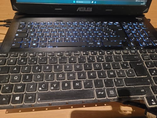 Avis d'un client : Nouveau clavier Azerty installé et rétroéclairé sur l'ordinateur, avec l'ancien au premier plan.