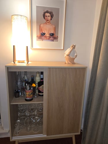 Customer's framed Majestic art print hanging above a wooden drinks cabinet.