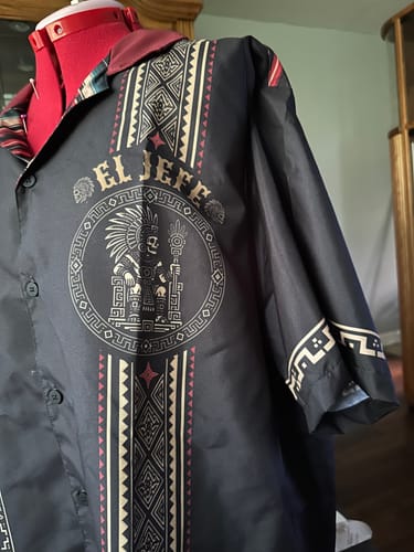 A customer's El Jefe Azteca Guayabera shirt on a dress form, showing the detailed Aztec graphics on the black fabric.