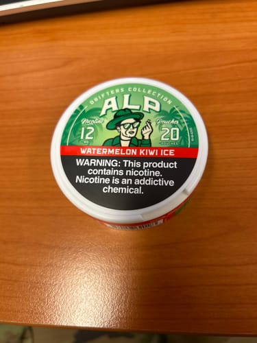 Customer's view of a Drifters Watermelon Kiwi Ice nicotine pouch tin resting on a wooden desk.
