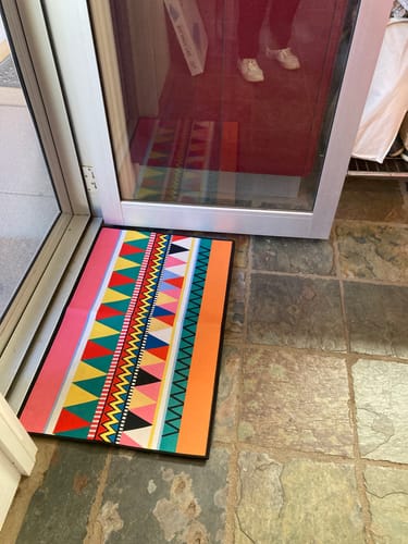 Customer's colorful Bohemian runner rug with a geometric pattern, placed on a slate tile floor by a door.