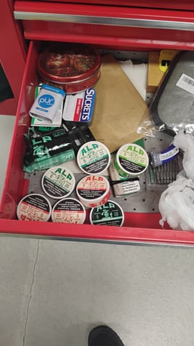 Customer's collection of Spearmint Nicotine Pouches inside a red toolbox drawer among other items.