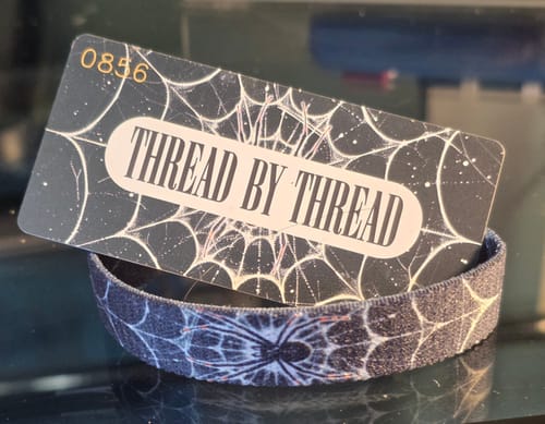Customer's 'Thread by Thread' bracelet from a Mystery Pack, featuring a dark, intricate spiderweb design.