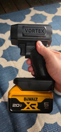 Reviewer holding the black Turbo Jet DB v3.0 blower attached to a yellow DeWalt battery pack.