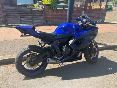 Customer's blue Yamaha R7 motorcycle parked on a street, showing the sleek tail tidy.