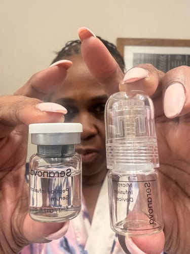 Reviewer holding the Seranova Micro Infusion Device and the Peptide Infusion Serum vial.