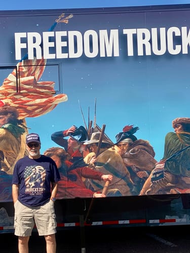 Customer wearing the blue Lincoln Eagle 250 T-Shirt while standing in front of a large decorated truck.