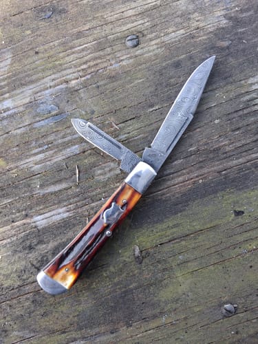 Customer shows a finished pocket knife with two patterned blades, made with the metal sanding belts.