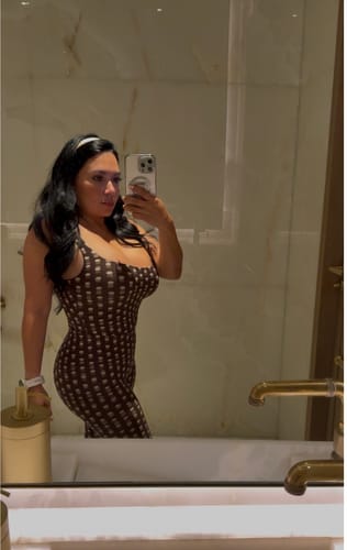 Reviewer in a mirror selfie wearing the printed Naked Print Capri Leggings and a matching top with a white headband.