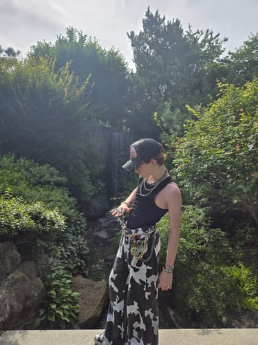 Reviewer wearing the black Scatter Brain Hat while posing outdoors, showcasing their stylish outfit.