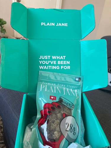 Customer's bag of Animal Mintz THCA flower inside the open, turquoise 'Plain Jane' shipping box.