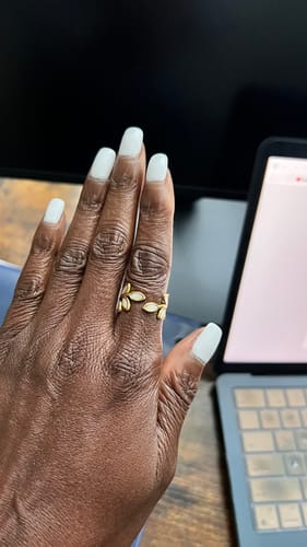 Close-up of a reviewer's hand wearing the adjustable Gold Leaf Ring.