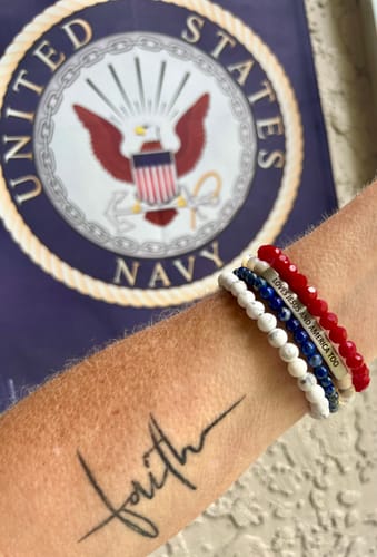 Customer wearing a stack of patriotic bracelets with the 'LOVES JESUS AND AMERICA TOO' engraving, shown with a US Navy emblem.