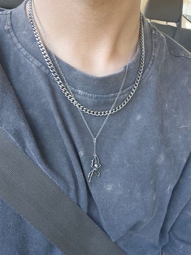 Reviewer wearing the silver Cuban Chain layered with a longer pendant necklace over a dark shirt.