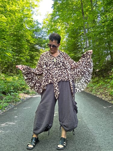 Reviewer posing outdoors in the Leopard Print Sheer Chiffon Blouse, highlighting its long, ruffled sleeves.