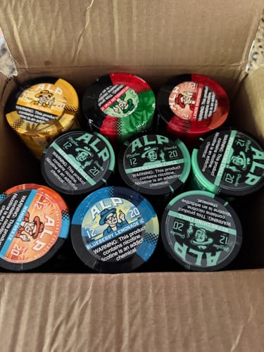 Customer's cardboard box filled with a variety of colorful ALP Drifters nicotine pouch tins.