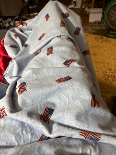 Customer's soft blue Patriotic Flag Blanket with an American flag pattern, shown bunched up in a living room.