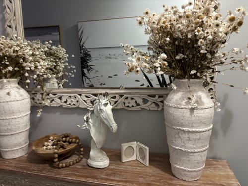 Customer's distressed white Apollon Horse Head Bust styled on a console table with vases and dried flowers.