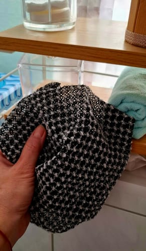 Customer holding the textured black and white Silkura Exfoliating Towel.