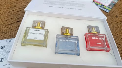 Customer's open OUD Supreme BUNDLE, displaying the three perfumes: Oud Serene, Oud Nirvana, and Ora 1776 in a white box.