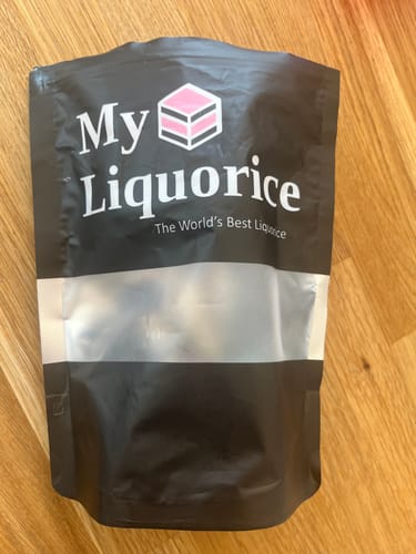 Customer's black My Liquorice pouch for their Sweety & Fruity Mix on a wooden surface.