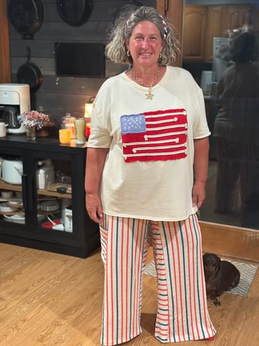 Customer standing in a kitchen wearing the Red & Blue Striped Wide Leg Lounge Pants with a patriotic t-shirt.
