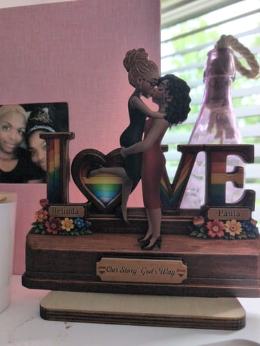 Customer's personalized LGBT+ Couple wooden plaque on a dresser. It shows two women kissing, forming the 'V' in 'LOVE'.