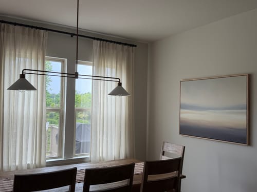 Customer's Layered Dusk Canvas Art hanging on a dining room wall next to a table and large window.
