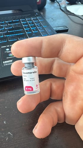 Un reseñador sostiene un frasco del péptido Tesamorelin de 10 mg en la mano.
