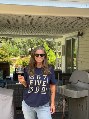 Reviewer standing on an outdoor patio wearing the navy 8675309 T-Shirt.