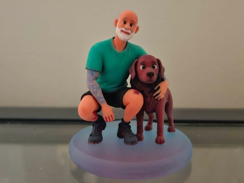 Customer's detailed 3D figurine of a person with an arm tattoo crouching to pet their brown dog.
