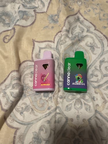 Customer's photo showing two vape pens from their order, one pink and one green, on a patterned surface.