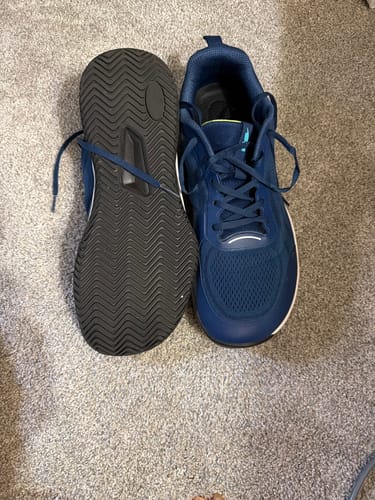 Customer's blue CUURT Muuv court shoes, showing the top of one and the durable black sole of the other.