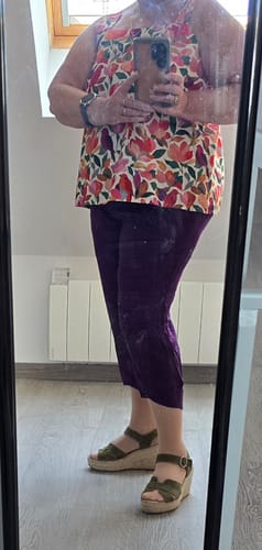 Une cliente portant la blouse ample Florence à imprimé fleuri dans un reflet de miroir.