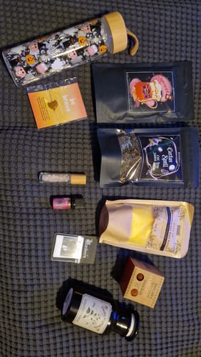 Kundenfoto zeigt die ausgepackten und liebevoll arrangierten Artikel auf einer grauen Decke.