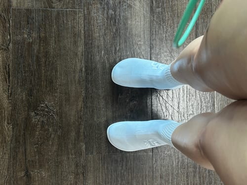 Customer's top-down view of the white Otishi 2.0 'Andes Snow' shoes on a dark wood floor.
