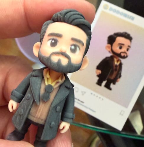 Close-up of a customer holding a detailed Custom Occupation Figurine of a man with a beard wearing a dark coat.