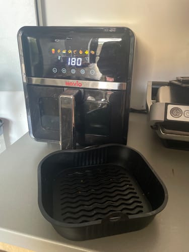 Customer's black Air Fryer Novio StonePro turned on, with the digital display showing 180 degrees and the basket liner in front.