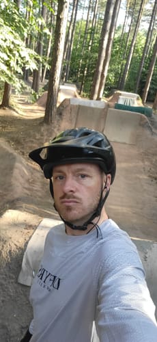 Reviewer in a helmet wearing the silver Reaper Long Sleeve Jersey at a dirt bike park.