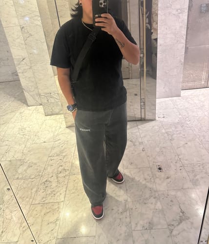 Reviewer showing the relaxed fit of the dark gray Classic Baggy Sweats in a mirror selfie.