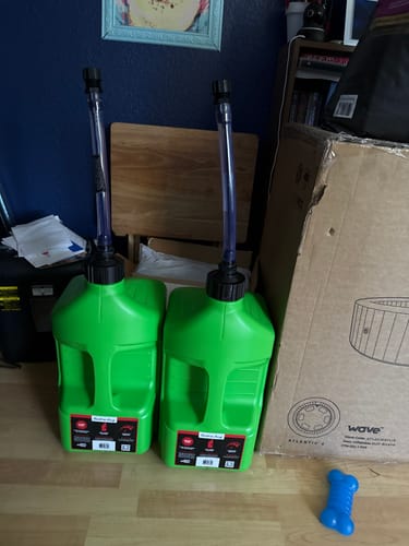 Customer's two new green 5 Gallon Jugs with spouts attached, standing side-by-side indoors.